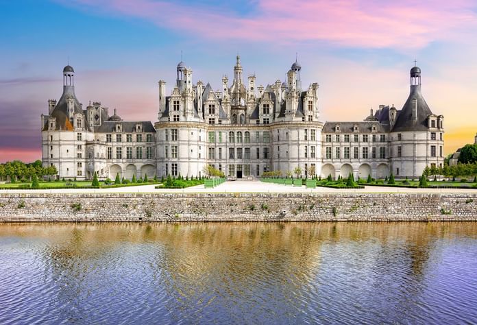 Exterior of Château de Chambord with a lake near Oceania Hotels