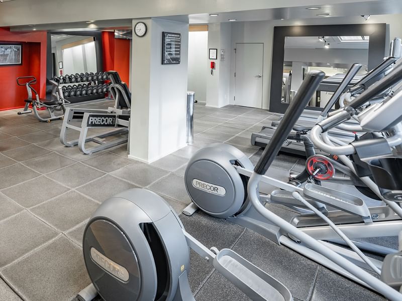 Fitness center featuring cardio equipment and weights.