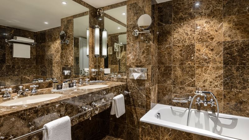 Bathroom vanity area with bathtub in Warwick Suite at Warwick Brussels
