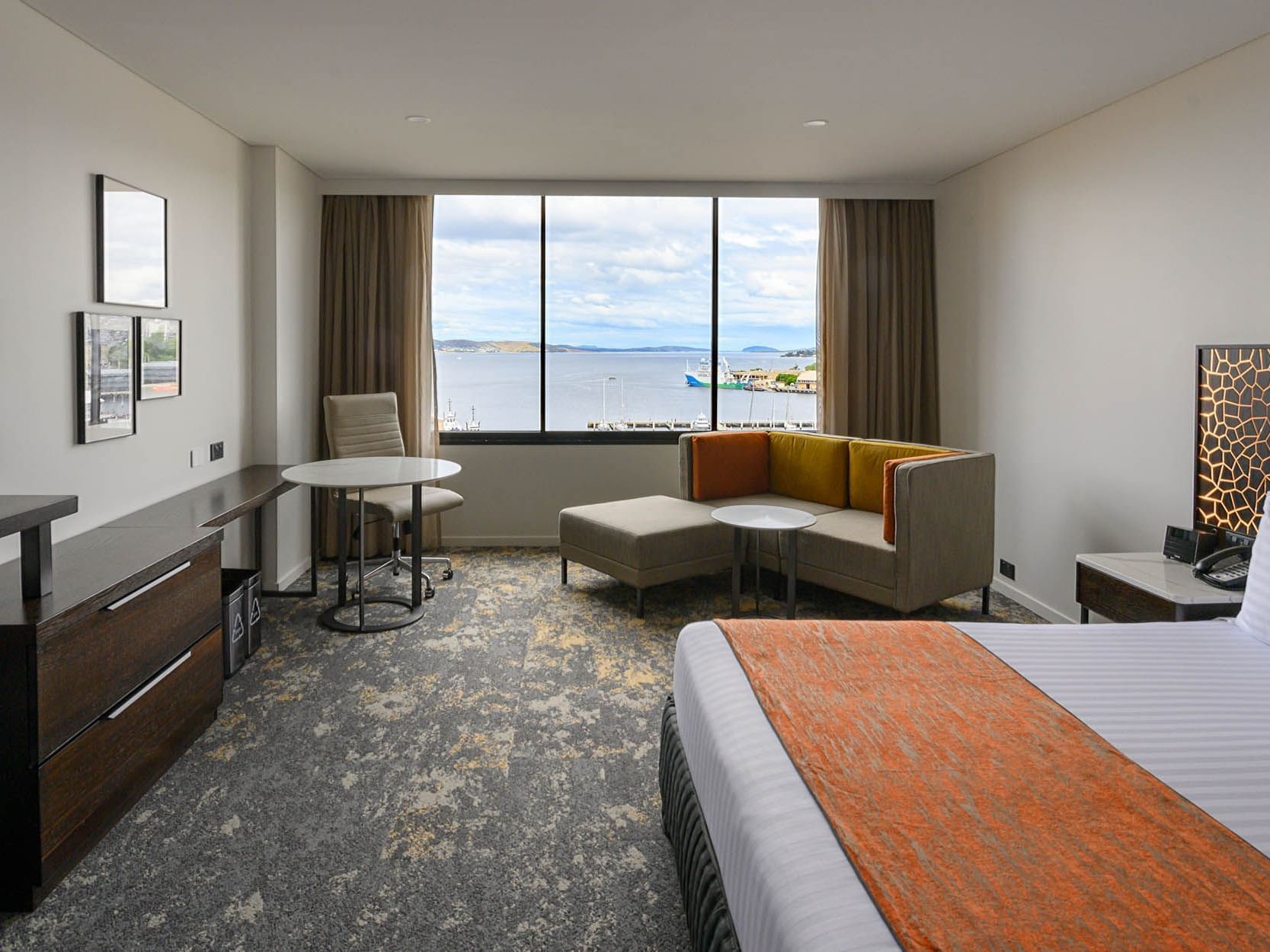 King bed & lounge with a harbour view in Superior Harbour room at Hotel Grand Chancellor Hobart