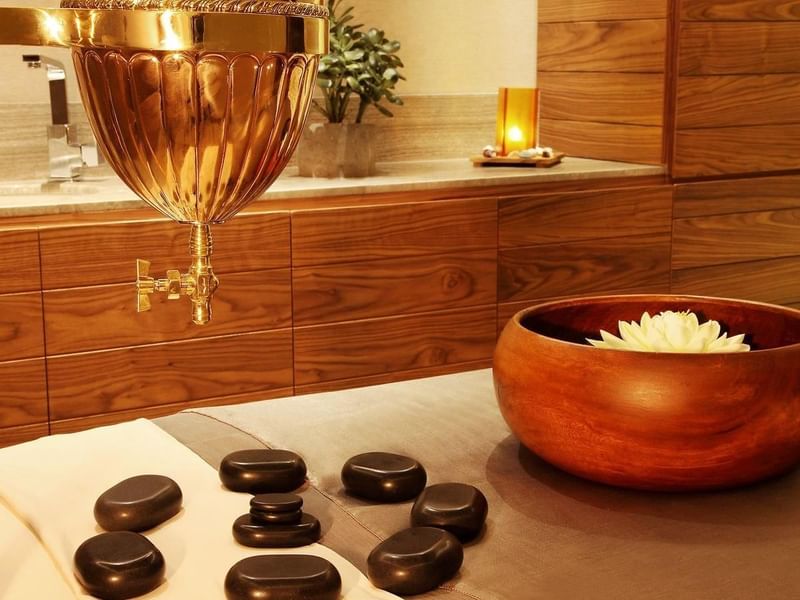 Massage bed with stones & a wooden bowl at Live Aqua Resorts
