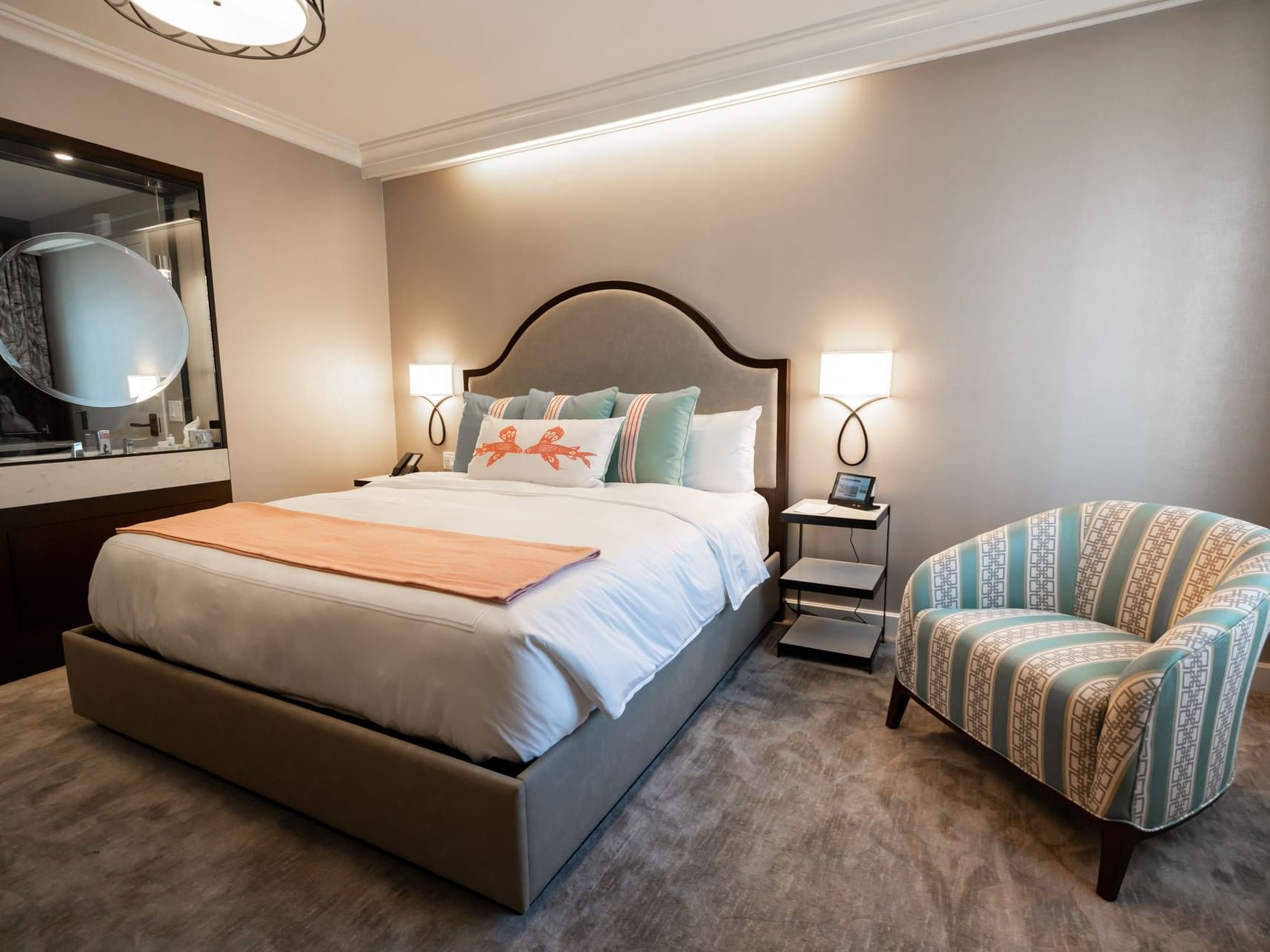 Nightstand and cozy chair by the king bed in Avalon King at Hotel Atwater