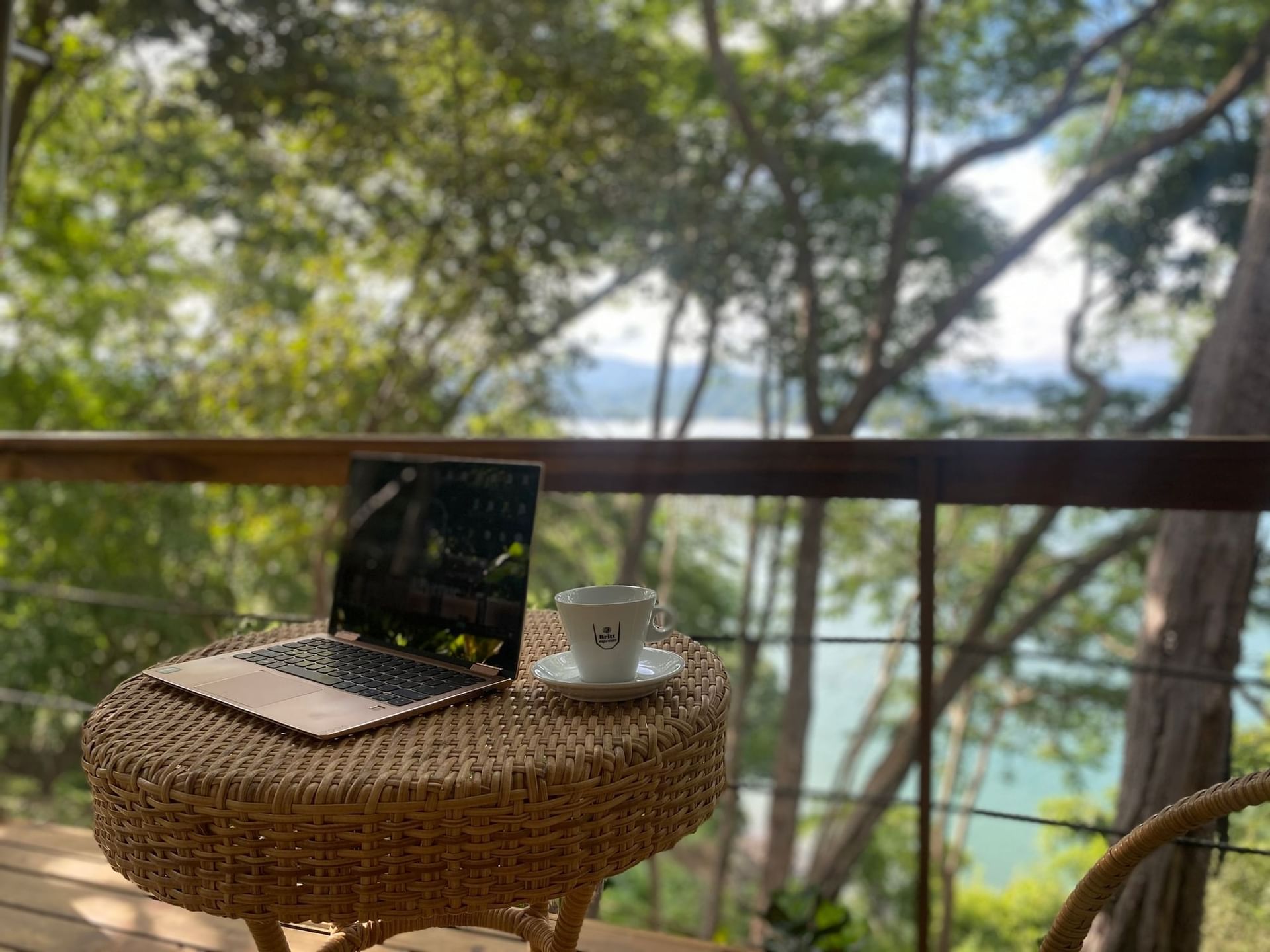 Opened laptop in the balcony overlooking the sea at Isla Chiquita Glamping Hotel