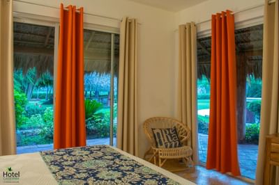 Junior Suite at La Casita by the Hub, offering a lovely balcony view of lush tropical gardens and thatched roofs