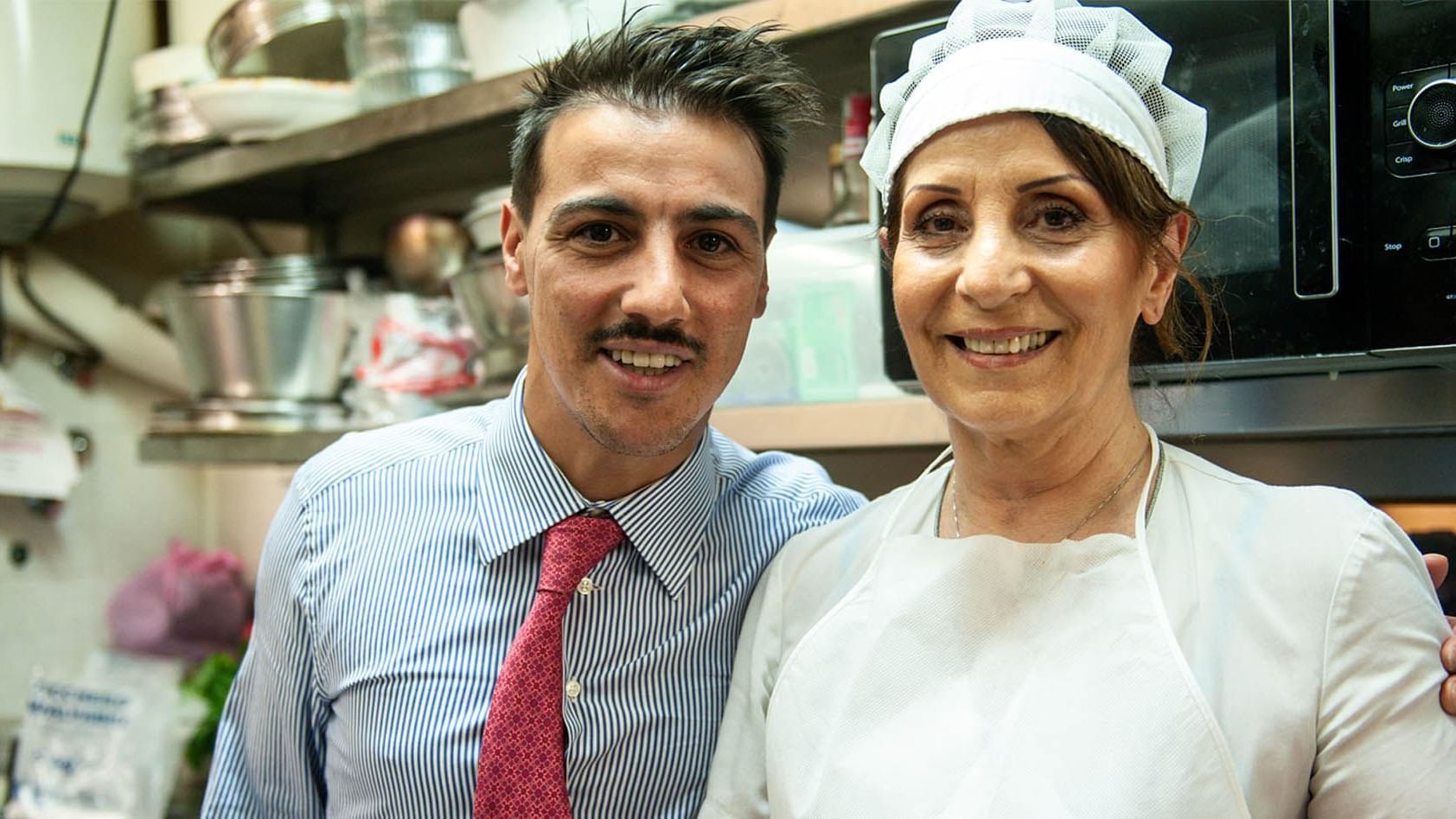 Two employees posing for a picture at Hostaria Da Pietro restaurant near Rome Luxury Suites
