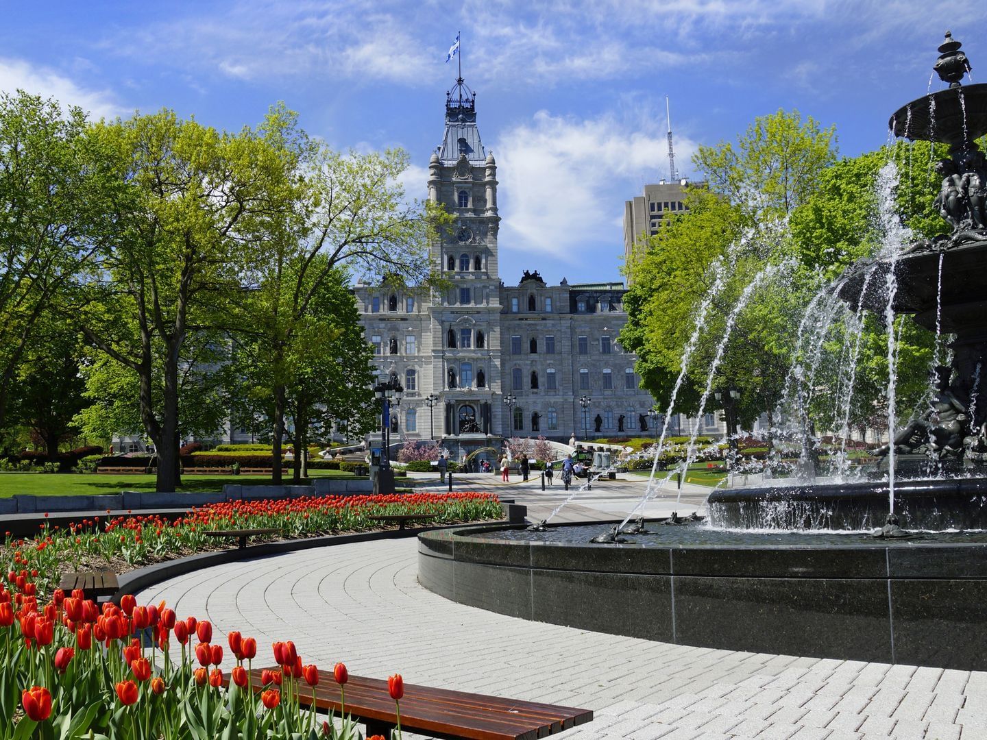 Red tulip flowers surrounding a water fountain near Travelodge Hotel & Convention Center Québec City