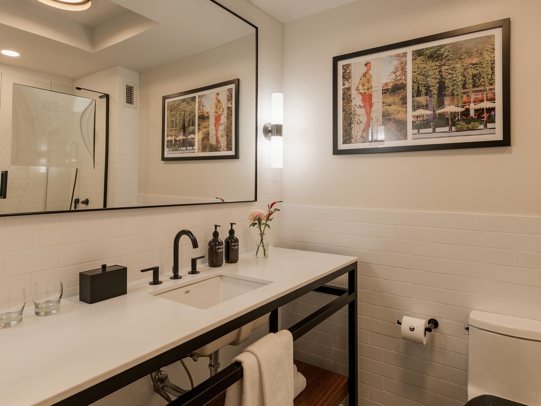 Bathroom of Deluxe Double Room with a modern sink, toilet, and framed pictures at Gansevoort Meatpacking NYC, New York.