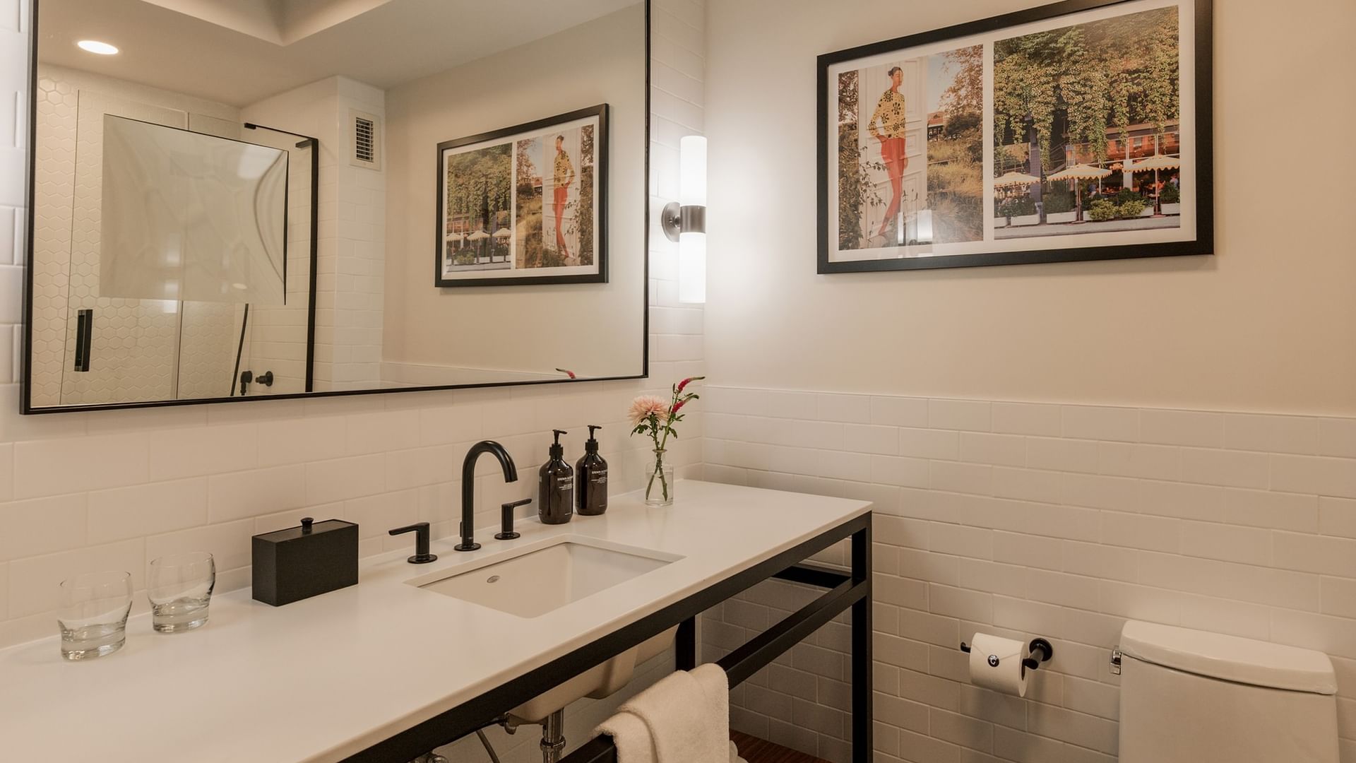 Modern bathroom with white subway tile, black fixtures, and framed artwork at Gansevoort Meatpacking NYC - NEW in New York.