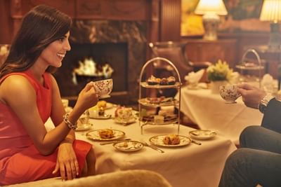 Couple having high tea by a fireplace at The Townsend Hotel