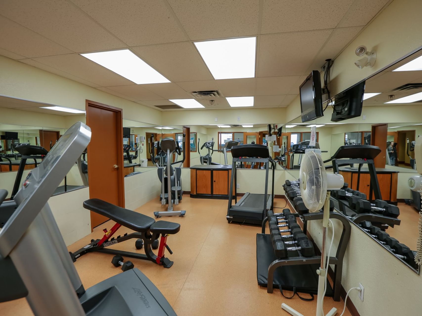 Fitness center with equipment and TV at The Glenmore Inn & Convention Centre