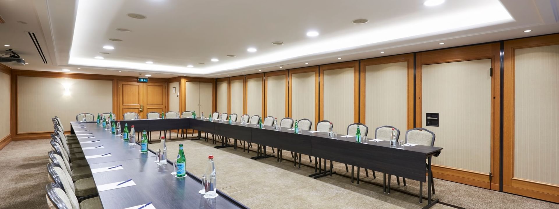 U-shaped table set up under recessed ceiling lighting in a Duquesnoy B at Warwick Grand Place Brussels