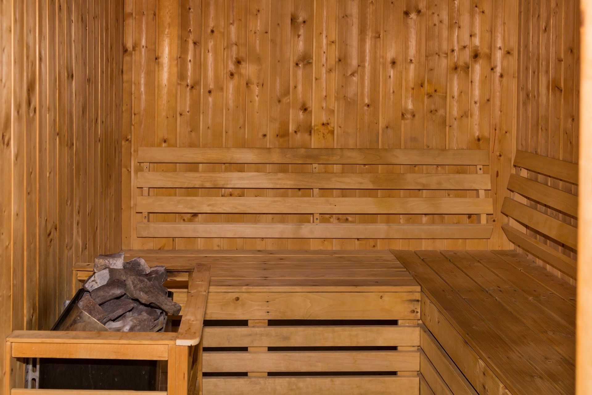 Sauna room with wooden walls & a bench in Spa at Warwick Doha