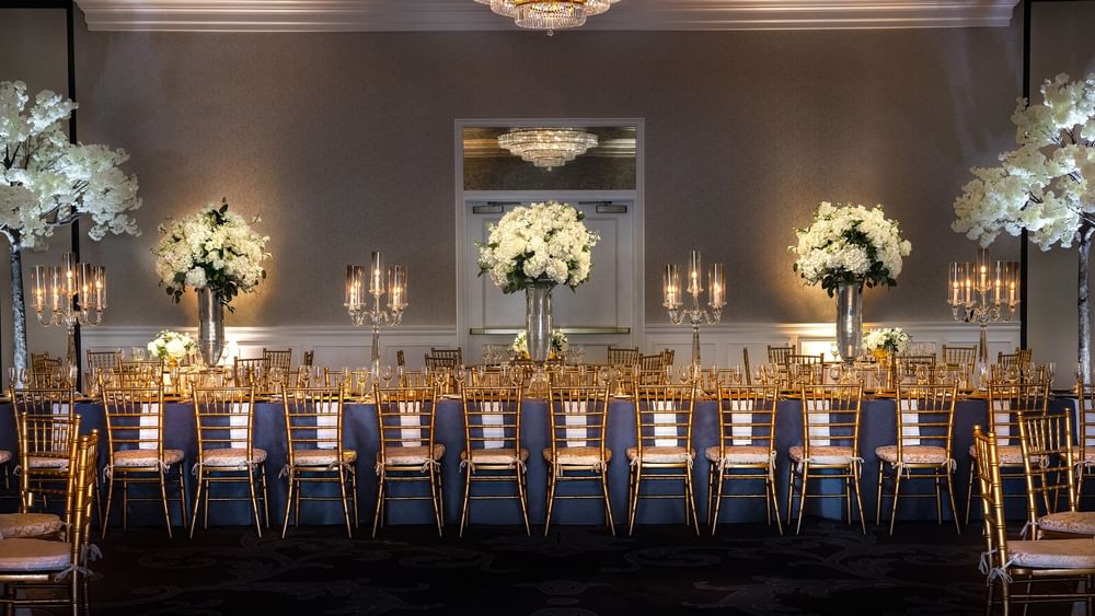 Elegantly set dining tables with gold chairs and white flowers at Turtle Creek Ballroom, Warwick Melrose Dallas.