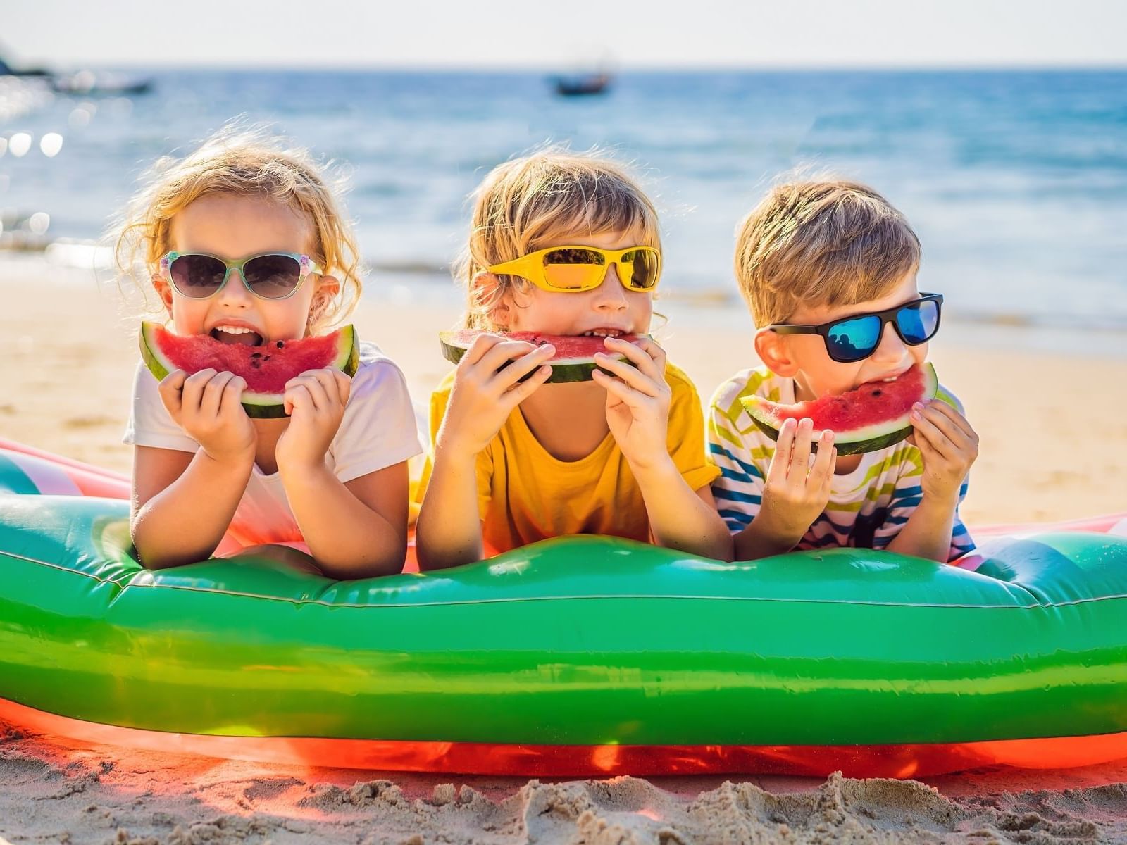 Kids eating watermelon on beach at Daydream Island Resort