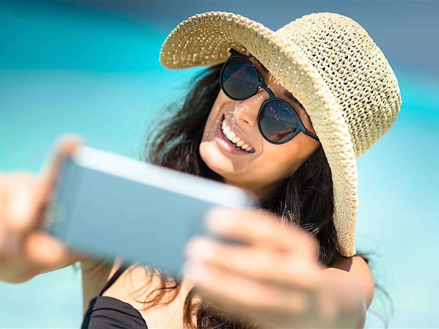 Lady taking a selfie with a backdrop of the ocean on a sunny day at Accra Hotels & Resorts