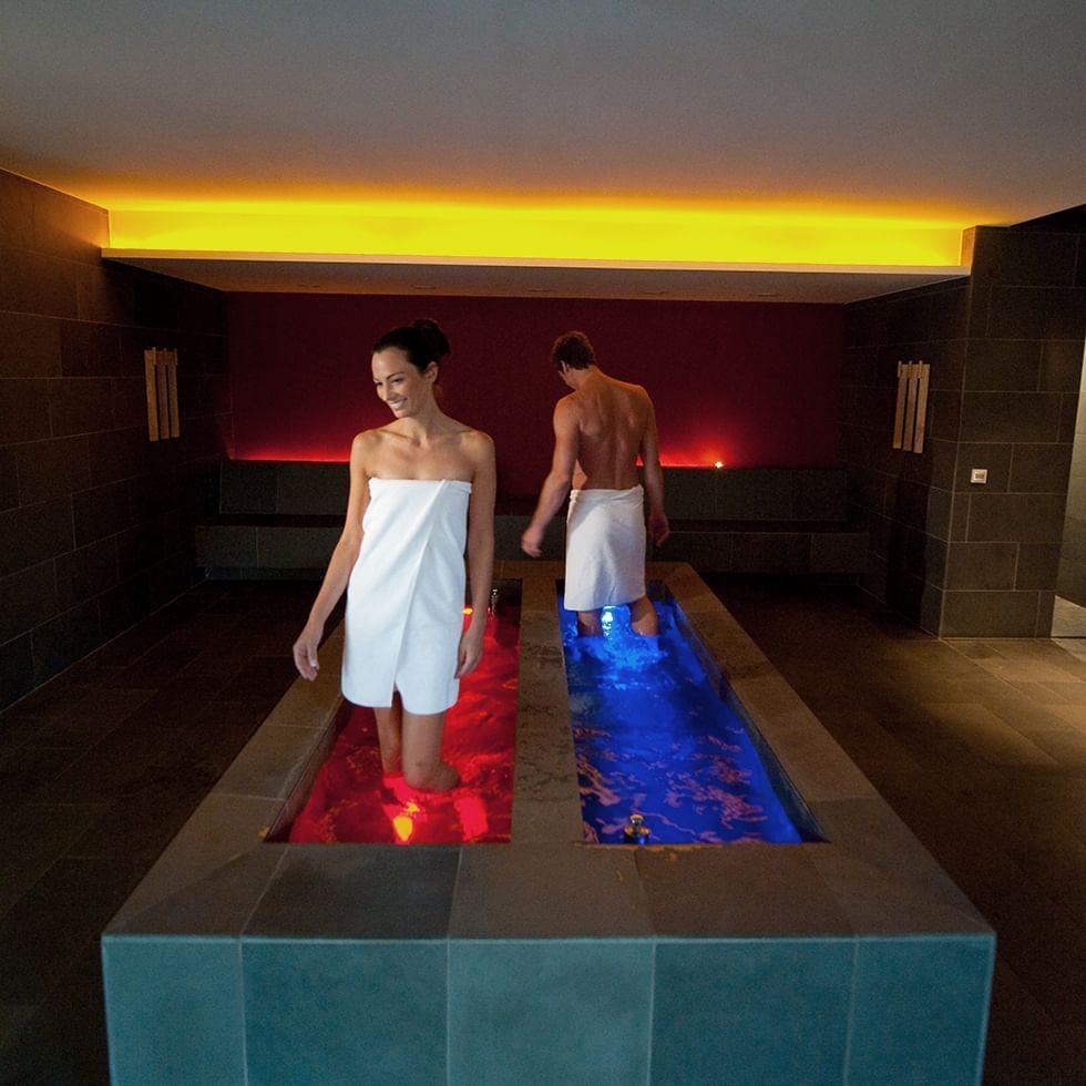 A couple in a private spa jacuzzi at Falkensteiner Hotels