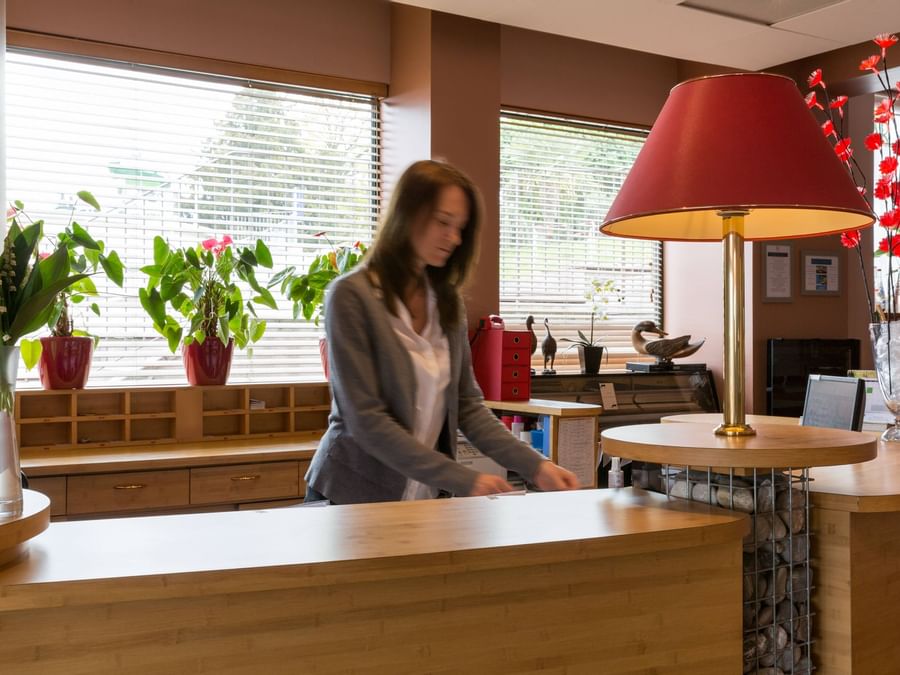 A receptionist at the reception desk in Hotel Alize