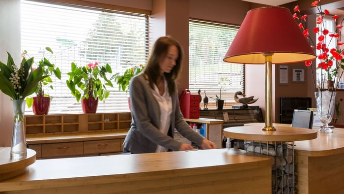 A receptionist at the reception desk in Hotel Alize