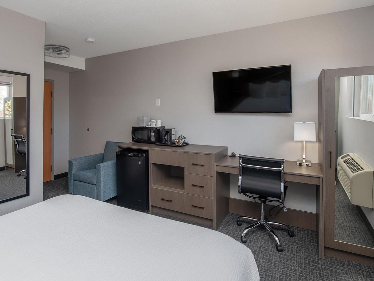 Hotel room with a desk, chair, TV.