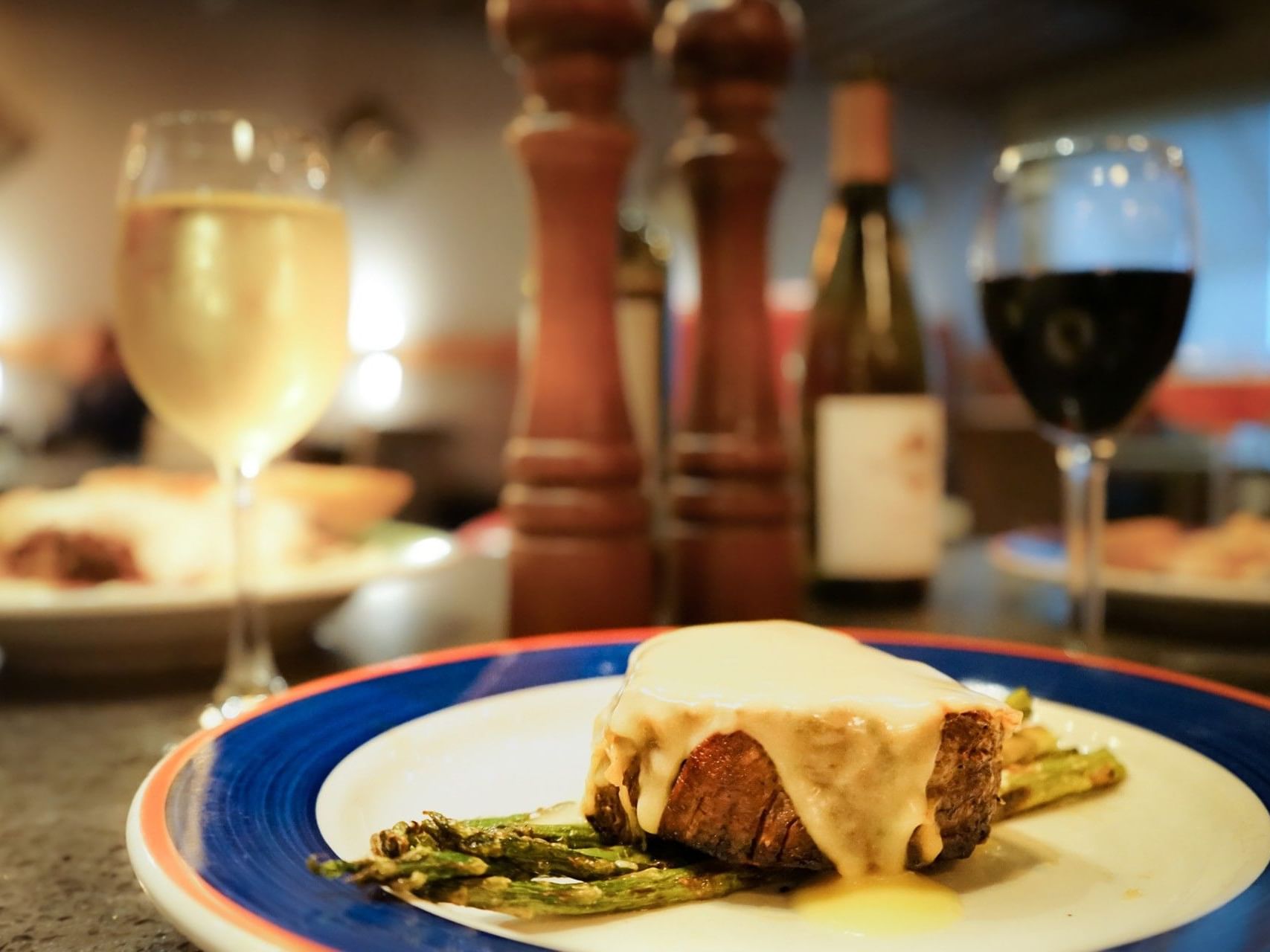 Doe's Eats Place near The White House Hotel, a thick steak with sauce and asparagus, served with wine and pepper grinders