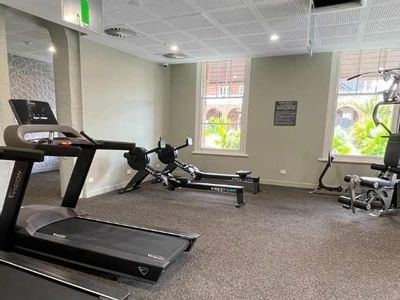 Gym with treadmills, rowing machine and strength training equipment at UniLodge Herston.