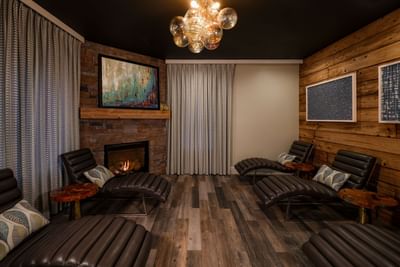 Cozy relaxing room with fireplace, wood paneling, and leather chairs at the Inn at Willow Grove