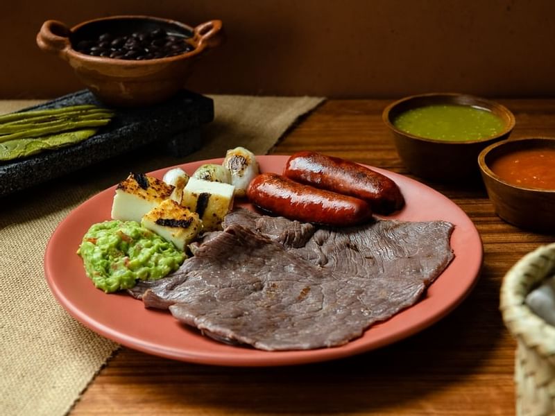 Comida servida con queso asado y salchichas en One Hotels