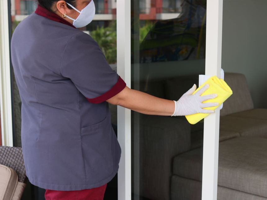 Staff cleaning a window in a Room at Hotel Coral y Marina