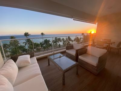 A balcony lounge area with evening ocean view at Club Hemingway