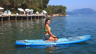 Woman on surfing board in the sea near Kairaba Mythos Palace