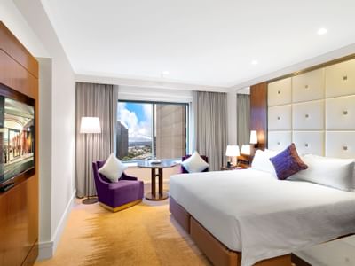 Bed & lounge in Deluxe Tower King Room at Amora Hotel Sydney