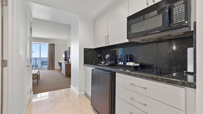 Kitchenette with black granite, microwave, and view of the bedroom in Oceanfront Studio 2 Queens at The Atlantic Hotel & Spa