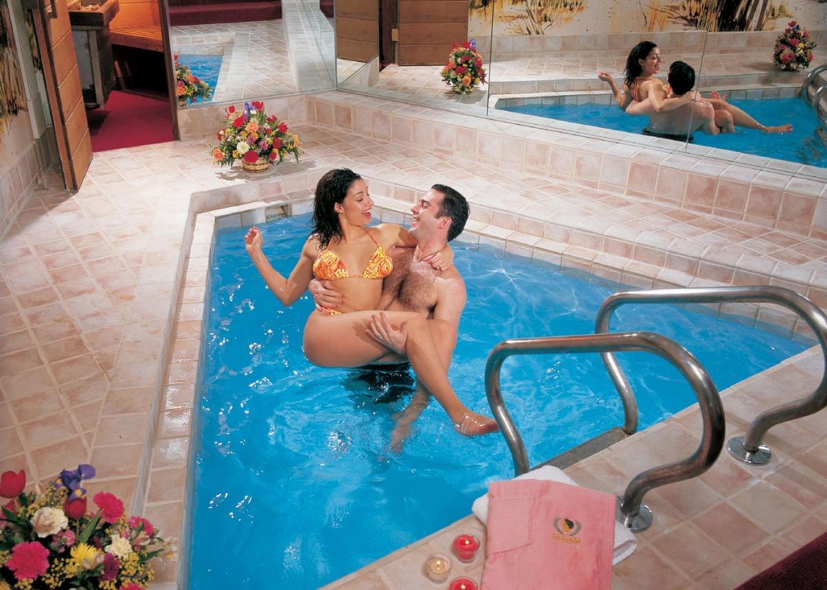 A couple relaxes together in a hot tub and enjoys a lovely moment at Cove Pocono Resorts