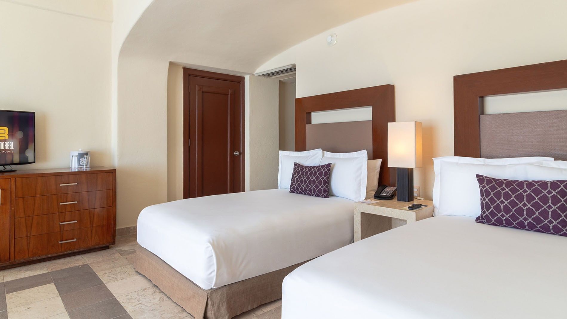 Nightstand and side cupboard by the bed in Partial Ocean View Two Double Deluxe Room at Camino Real Acapulco Diamante