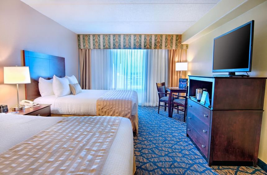 TV & work desk facing Two Queen Beds in a room at The Barrymore Hotel