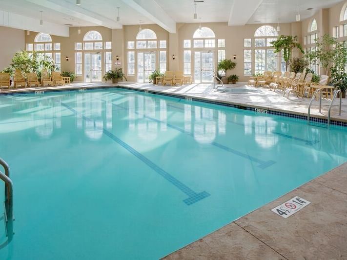 Indoor pool area with pool chairs at Westford Regency