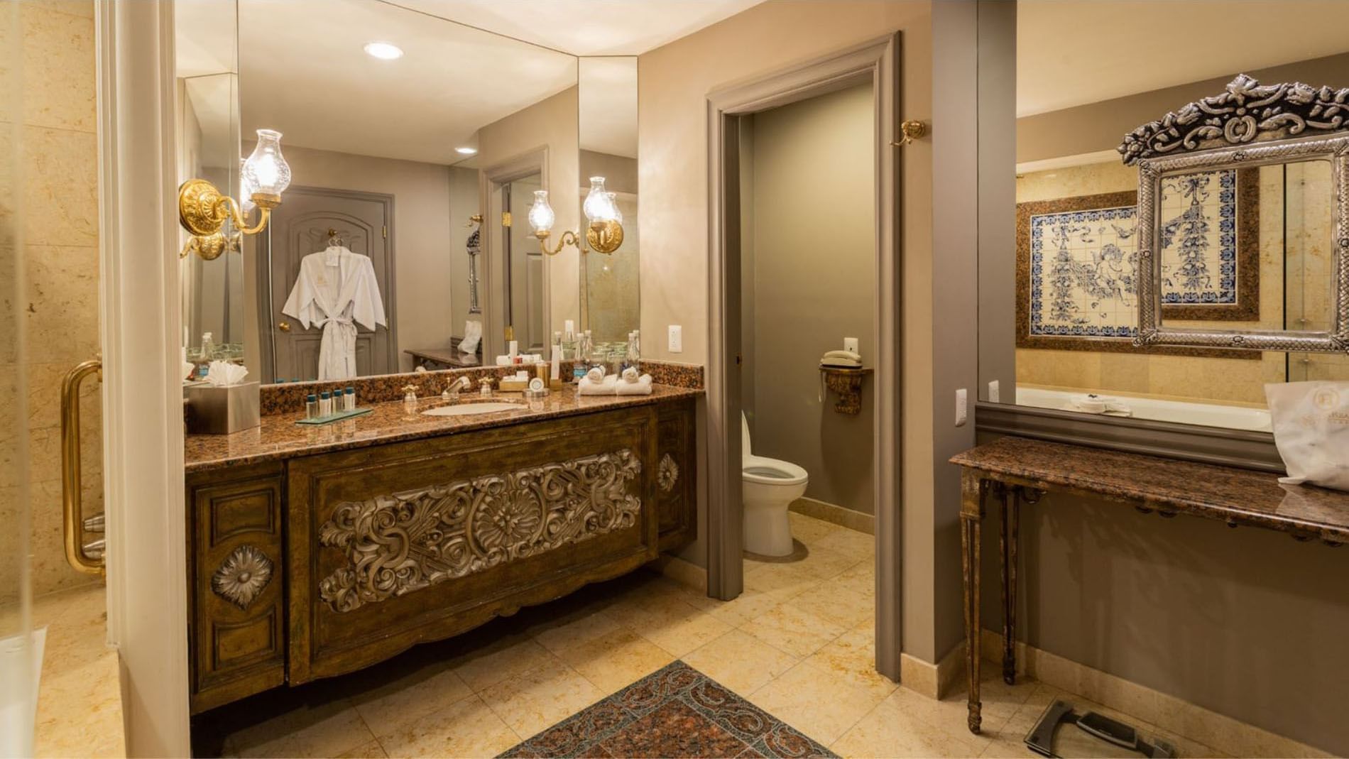 Luxury vanity in King Executive Tower showcasing intricate wood carvings and a large wall mirror at Quinta Real Monterrey