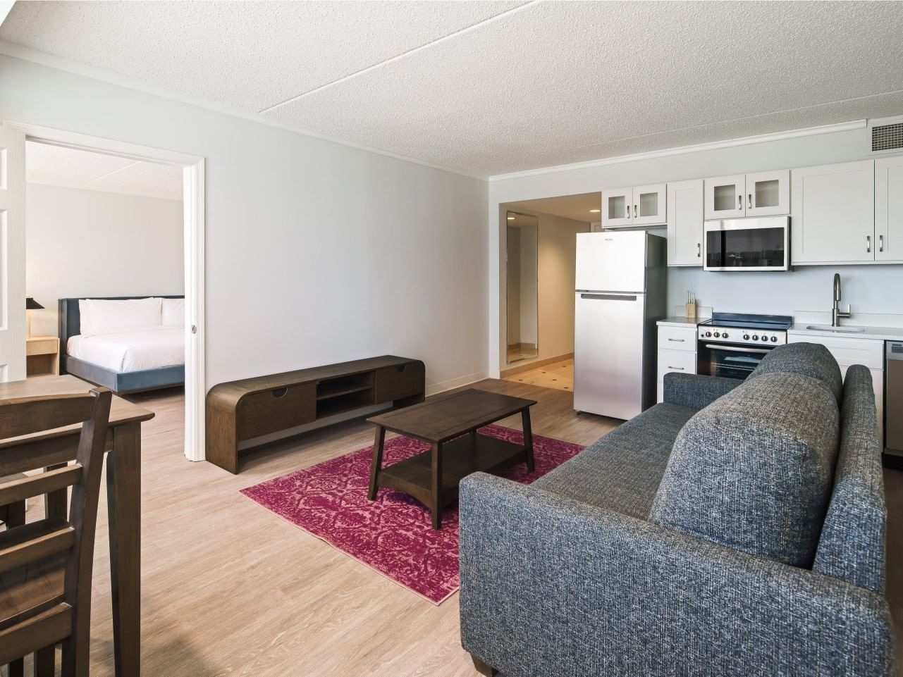 Open-plan living area with gray sofa, kitchen, and bedroom view at Showboat Hotel & Resort Atlantic City