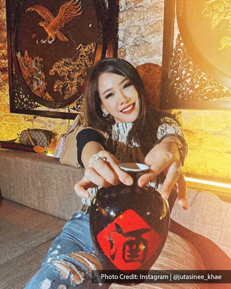 A lady holding a bottle of Chinese liquor - Lexis Suites Penang