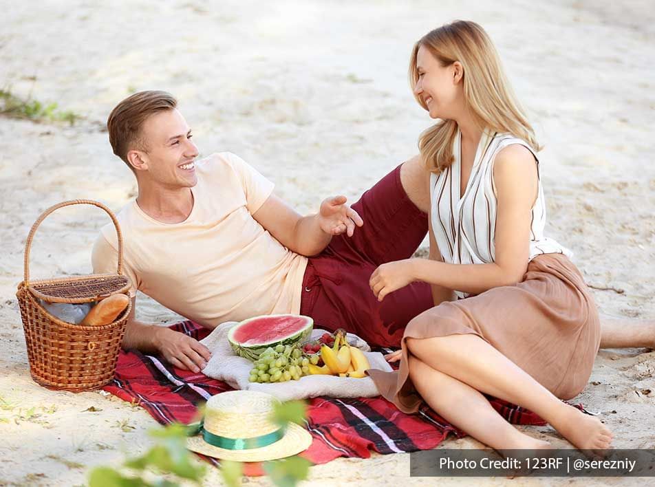 happy couple having a picnic on the beach - Grand Lexis PD