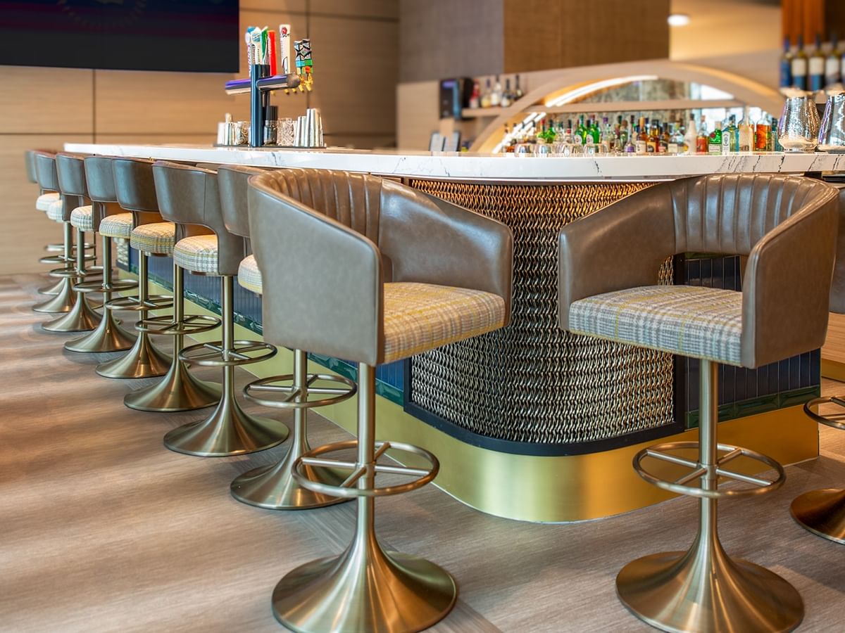 Modern bar with counter, seating, and stools.