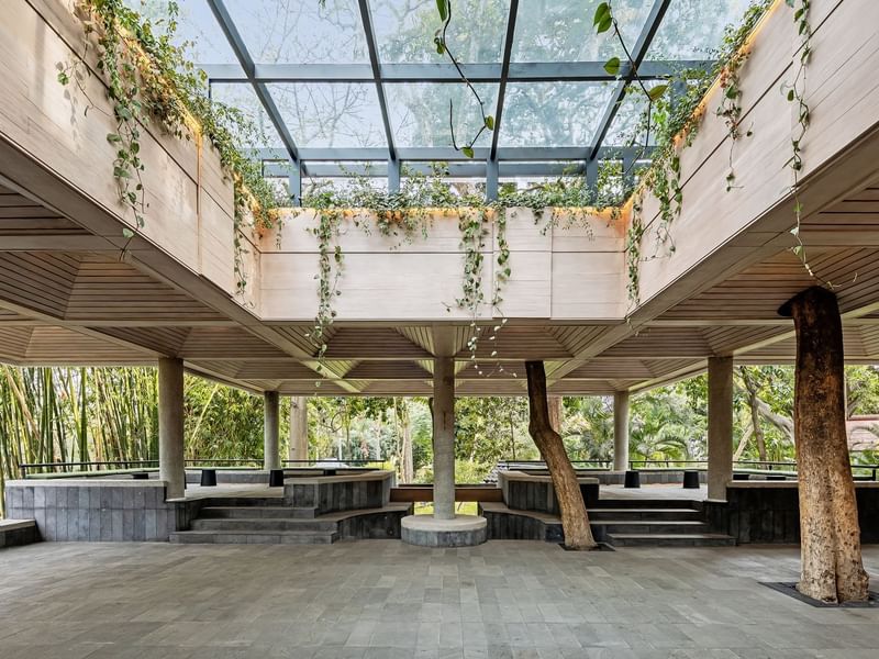 Open pavilion with a glass roof and abundant green vines hanging from the sides at Grand Fiesta Americana