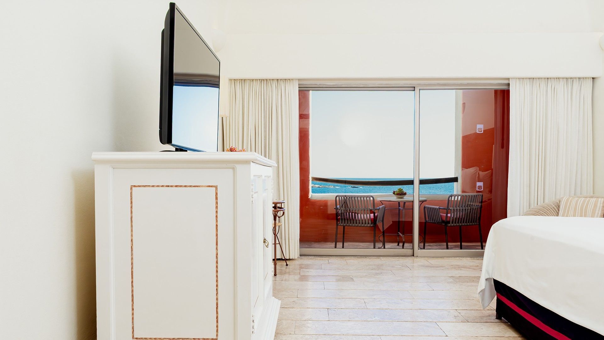 TV and dresser facing the bed in King Deluxe Bed with a private balcony seating area at Camino Real Zaashila Huatulco