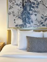 Bed with pillows under a large peacock wall art in Standard Room at Warwick Allerton Chicago