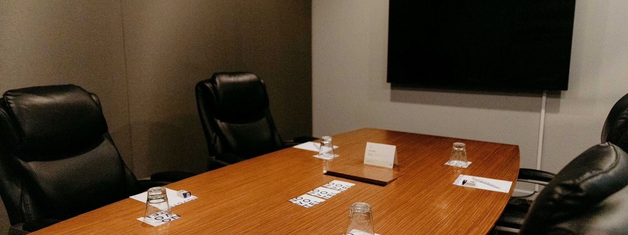Small boardroom setup with table and chairs at Novotel Sydney Parramatta.