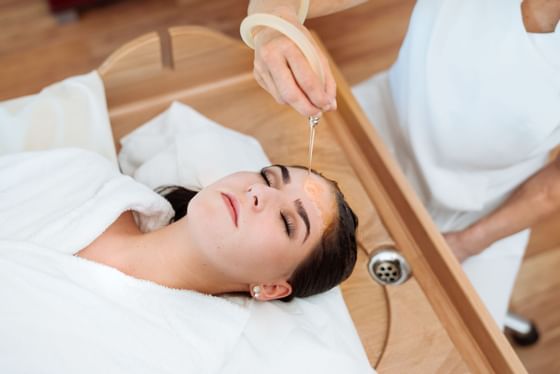 Closeup of a lady getting  Ayurveda treatment at Schloss Hotel