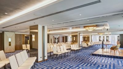 Willara-Kirralaa featuring long rows of cream chairs facing a small wooden stage at The Grace Sydney