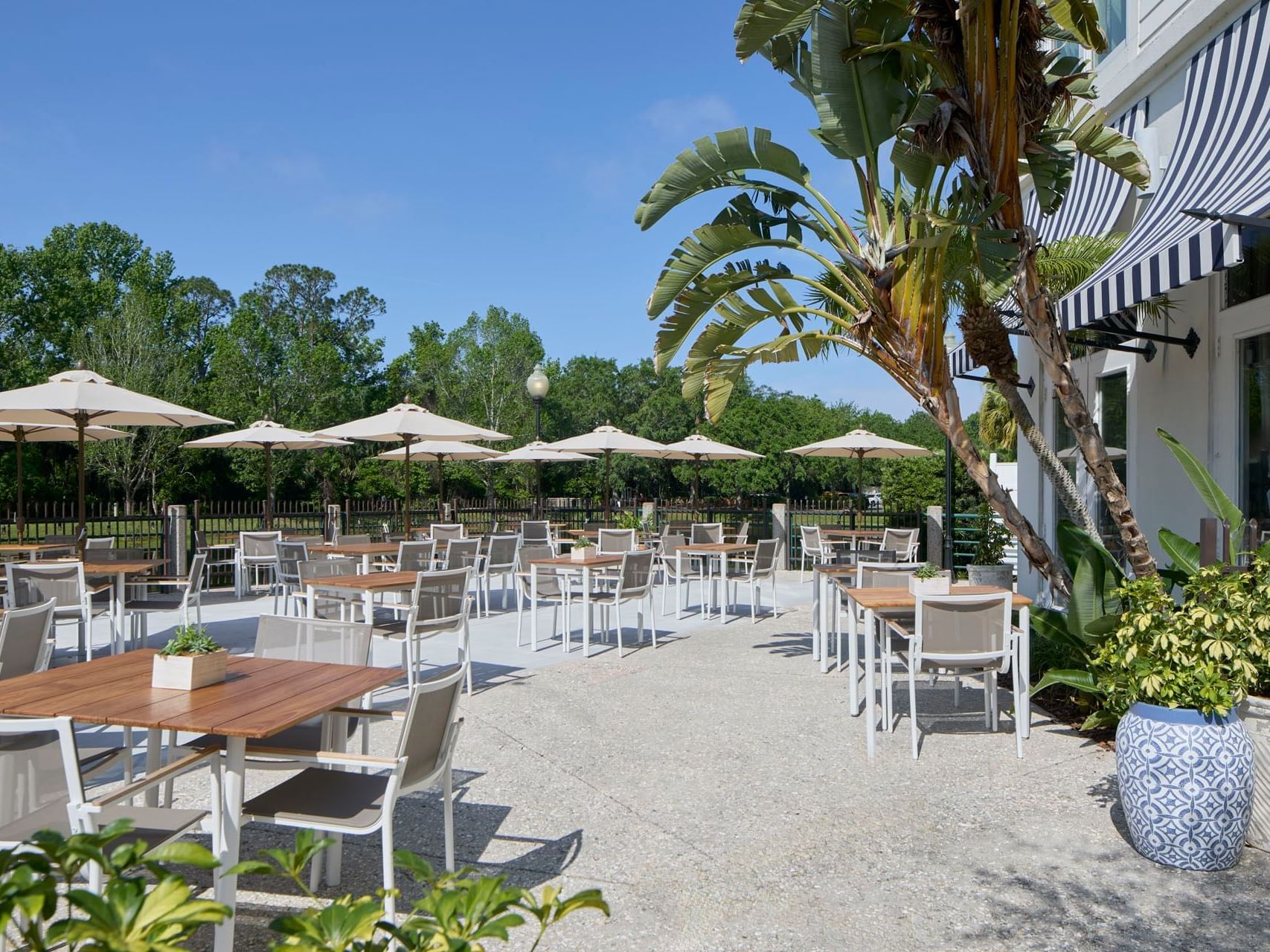 Lakeside Terrace of The Inn at Celebration, with tables under umbrellas, surrounded by palm trees