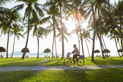 Man riding bike with a beach view at Pelangi Beach Resort & Spa