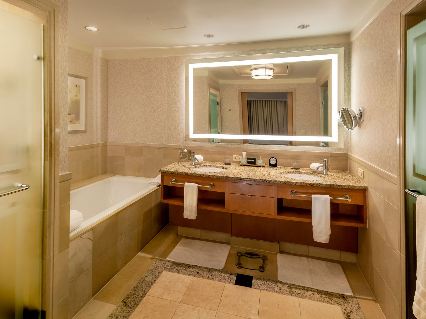 Luxury bathroom bathtub by the vanity with an illuminated mirror in Spa Level Suite at The Umstead Hotel and Spa
